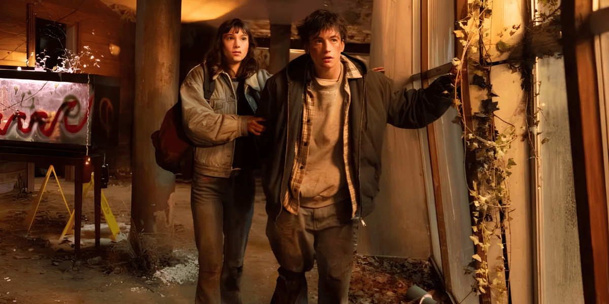 Two characters explore a dilapidated building, looking cautious amidst debris and dim lighting