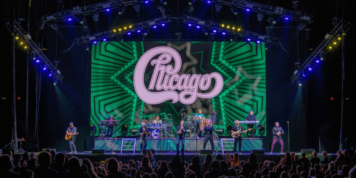 Chicago band performing live on stage with vibrant light display in background