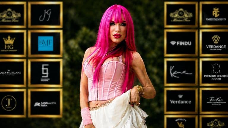 A woman with vibrant pink hair poses confidently for a photo, embodying the spirit of music and healing.