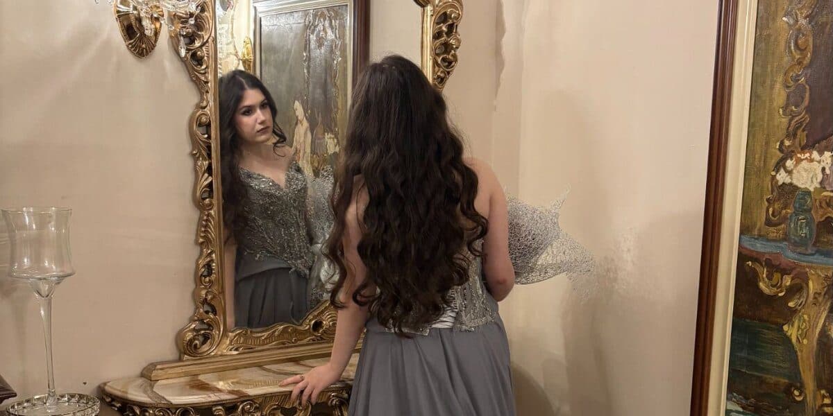 Jelena Kulic couture gown with intricate silver embellishments reflected in an ornate mirror, highlighting wearable art craftsmanship.