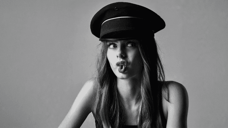 "Black-and-white portrait of Nelly Opitz, a 15-year-old athlete and model, wearing a hat and striking a playful pose."