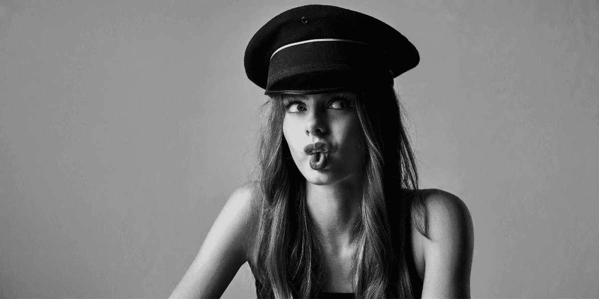"Black-and-white portrait of Nelly Opitz, a 15-year-old athlete and model, wearing a hat and striking a playful pose."