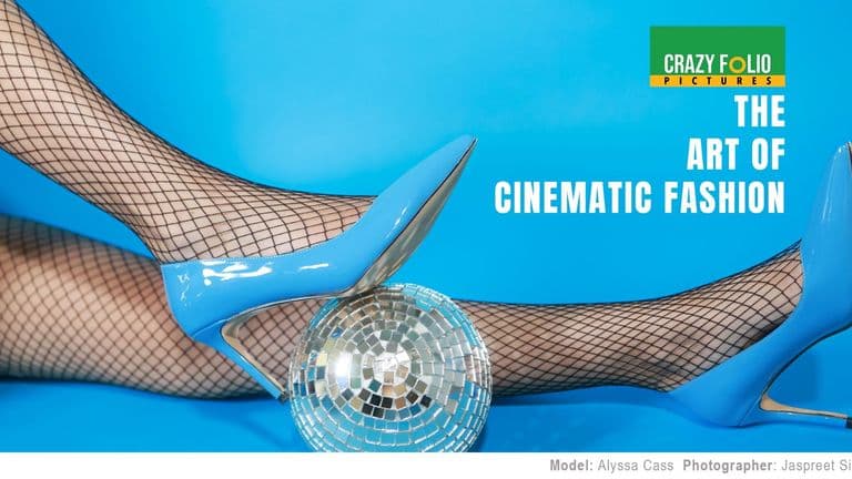 A pair of blue high heels on fishnet stockings next to a disco ball