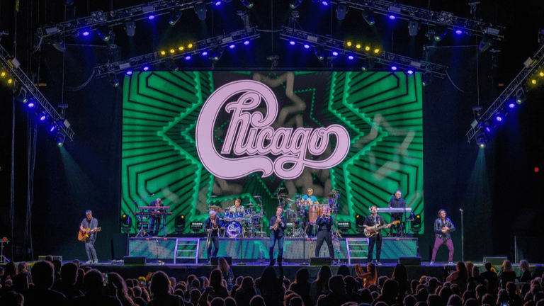 Chicago band performing live on stage with vibrant light display in background
