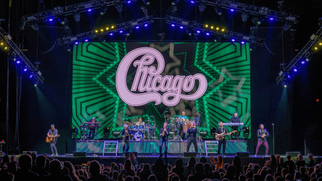 Chicago band performing live on stage with vibrant light display in background