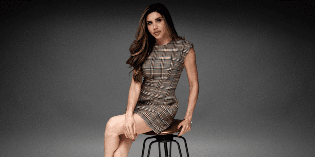 How to Build an Empire From Scratch: Inside the World of a Founder Raising Three Daughters Lisa Haven seated on a stool wearing a plaid dress during a professional portrait for her founder profile.